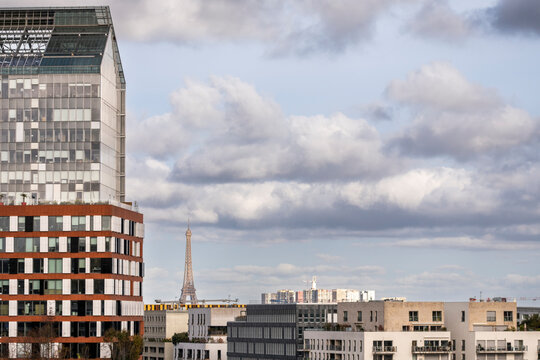 Dramatic clouds over a modern city skyline in Boulogne Billancourt Paris France with residential architecture and Eiffel on the horizon
