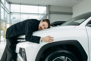 Happy bearded man hugging his new white car