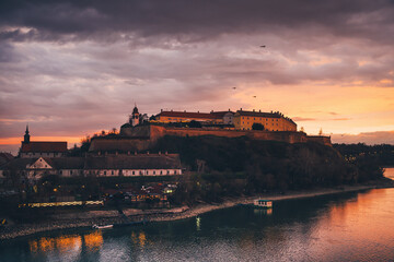 Obraz premium Petrovaradin fortress at dramatic sunset over Danube river in Novi Sad, Serbia