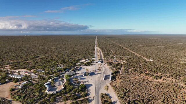 Border Village between South Australia and Western Australia, Eyre Highway, Nullarbor Plain: 4K aerial drone footage of remote roadhouse, boder control, Vehicles, outback highway and vast wilderness