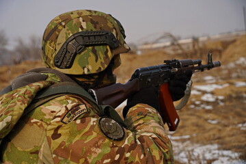 Naklejka premium Almaty, Kazakhstan - 01.20.2026 : A soldier with a rifle in position. Military exercises.