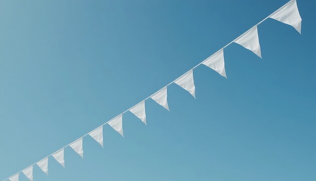 A string of triangular white flags hangs diagonally against a clear blue sky with a subtle gradient effect.