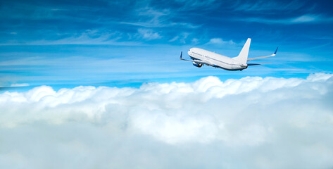 Airpane flying high in the sky over the fluffy cumulus clouds, air travel background with airplane...