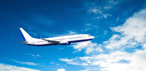 White passenger airplane flying high in the sky among the clouds, travel by air background with...