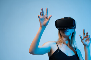 Woman interacting in virtual space using VR headset, immersive digital technology and future...