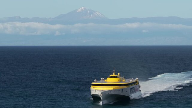Cinematic aerial view of the Fred Olsen speed ferry crossing between Agaete and Santa Cruz de Tenerife