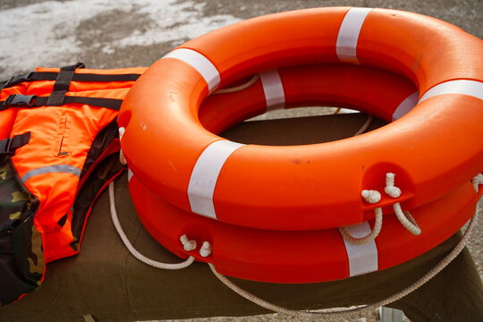An orange lifebuoy. An orange life jacket.