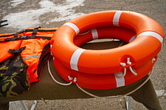 An orange lifebuoy. An orange life jacket.