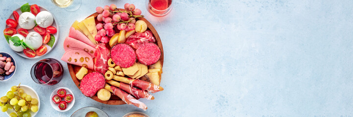 Italian Antipasti panorama. Charcuterie platter with cheese and other snacks, overhead flat lay panoramic shot with copy space