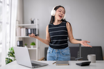 Young woman enjoying music while working remotely