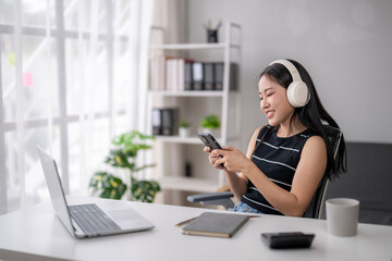 Young woman enjoying music while working remotely