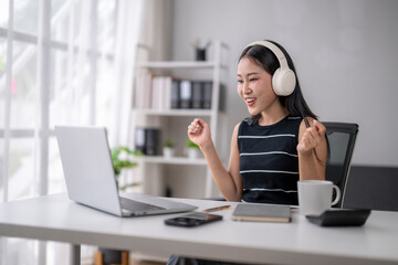 Asian freelancer celebrating success while working from home office