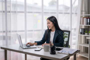 Professional woman working on laptop in modern office