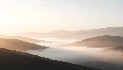 Misty mountain landscape at sunrise with soft golden light
