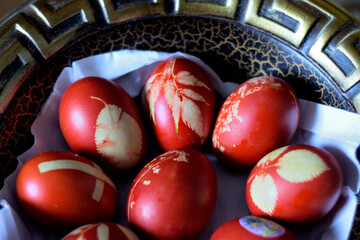 Decorative bowl filled with colorful red Easter eggs adorned with intricate designs