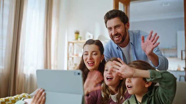 Online family holding tablet closeup. Smiling parents children waving tab online