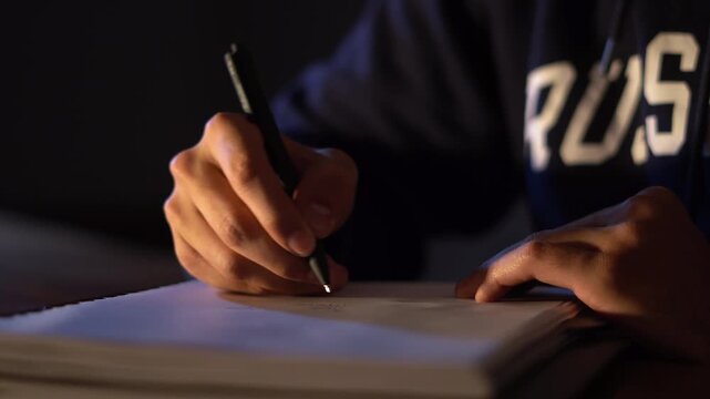 Writing on the notebook with a pen