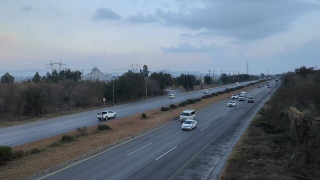 A beautiful winding road going through a patch of green trees on each side.Kashmir Road near Chattar Park, Punjab, Pakistan (01-23-2026) car and trafice View of Ring Road, Ring Road interexchange Isla
