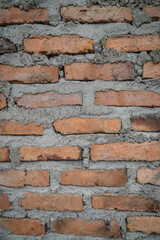 Obraz premium Close-up of weathered brick wall texture with visible mortar lines, showing rustic construction details and natural color variations.