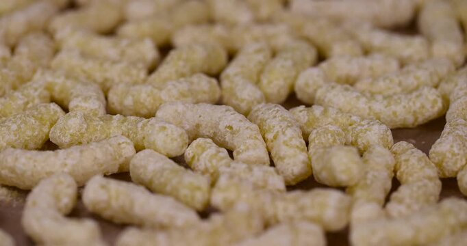 large sweet sticks of corn flour with added sugar for quick cooking with milk or yogurt and powdered sugar, ready-to-eat corn sticks scattered on food paper along with powdered sugar