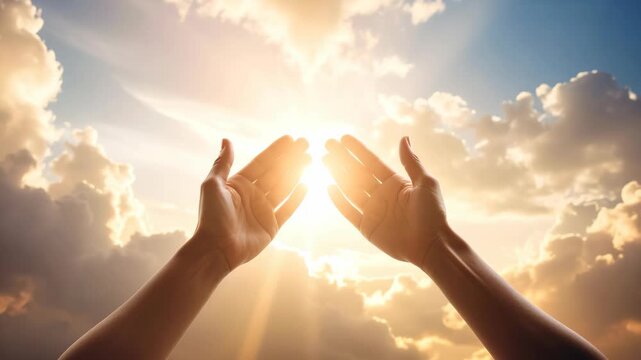 Hands reaching up towards bright sunlight breaking through clouds