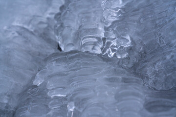 The Gleiersch Gorge in winter with snow, ice, and hanging icicles.