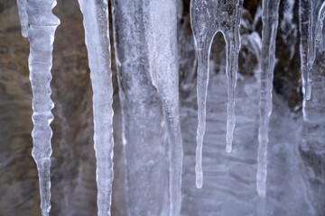 The Gleiersch Gorge in winter with snow, ice, and hanging icicles.