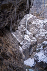 The Gleiersch Gorge in winter with snow, ice, and hanging icicles.