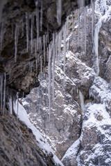 The Gleiersch Gorge in winter with snow, ice, and hanging icicles.
