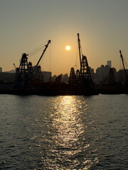Fototapeta premium クレーン船に挟まれた夕日の港景