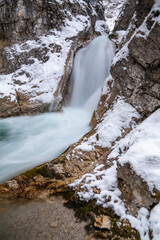 The Gleiersch Gorge in winter with snow, ice, and hanging icicles.