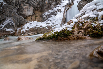 The Gleiersch Gorge in winter with snow, ice, and hanging icicles.