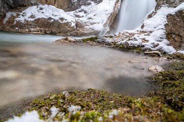 The Gleiersch Gorge in winter with snow, ice, and hanging icicles.