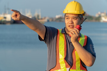 Harbor Overseer: A focused construction worker, clad in a safety vest and helmet, navigates the...