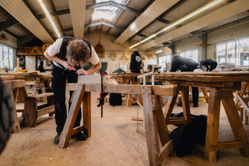 Zimmermann fixiert Holz mit Klemmen