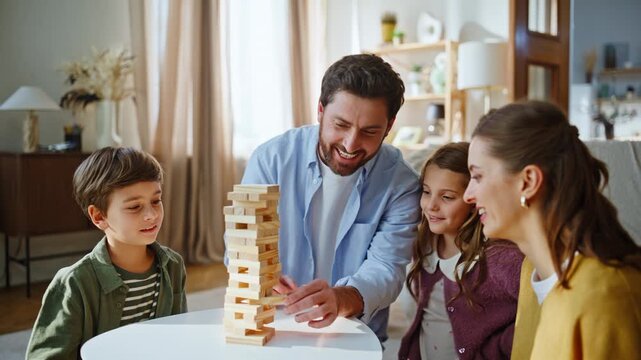 Dad removing jenga block knocked down wooden tower at flat closeup. Home leisure