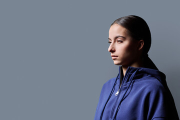 Profile portrait of young serious teenage girl on gray background © Valerii Honcharuk