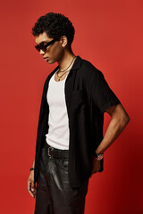 Fototapeta premium Stylish young African American man posing confidently in trendy sunglasses