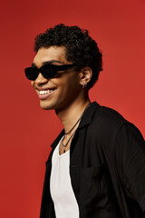 Obraz premium Stylish young man exuding confidence in trendy sunglasses within vibrant studio backdrop