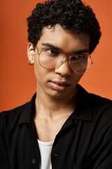 Obraz premium Handsome young african american man in stylish eyeglasses posing in a vibrant studio