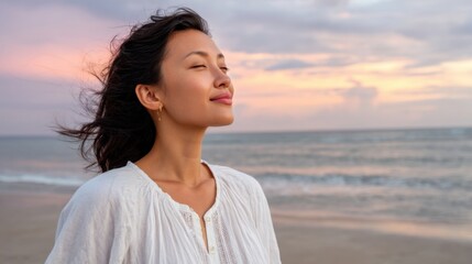 Peaceful Asian woman enjoying the sunset on a beach, gazing at the horizon with a soft breeze 