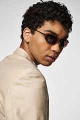 Obraz premium Handsome young african american man in stylish sunglasses poses in studio setting