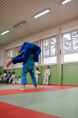 Obraz premium Two young athletes show their judo skills in front of the coaches