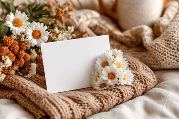 Fototapeta premium Top-view Mother?s Day card on knitted blanket with delicate flowers flat lay