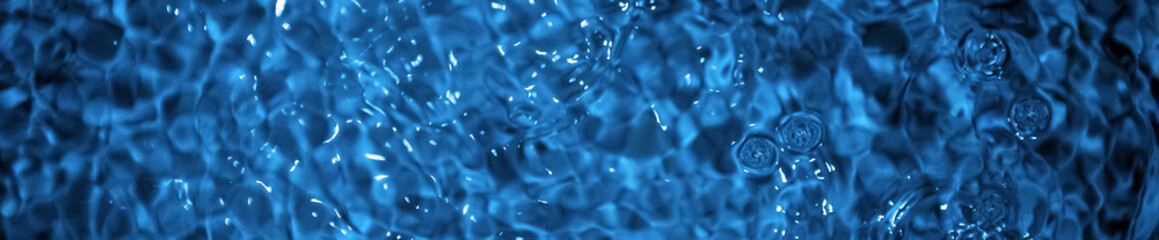 Water surface panoramic view. Calm glossy blue water texture as a background