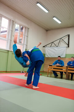 Two young athletes show their judo skills in front of the coaches