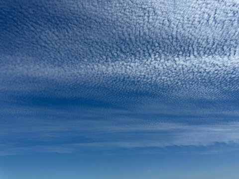 Cirrocumulus clouds in blue sky.