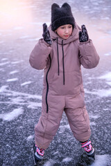 Child practicing ice skating skills on a frozen lake, learning balance, coordination and confidence...