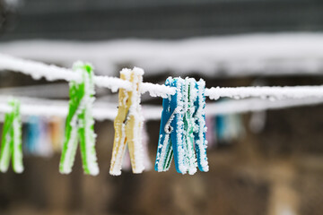 A line of clothespins are frozen in the snow