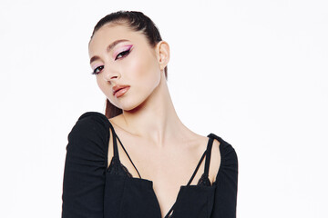 Young woman with flawless skin wearing bold pink eyeliner posing confidently in a minimalist black...
